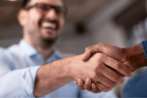 Two business men shaking hands, symbolizing the successful completion of a business deal.