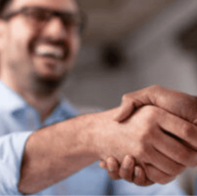 Two businessmen shaking hands, a visual metaphor for a successful M&A transaction in the vacation and cabin rental industry. Trust our expertise for seamless deals.